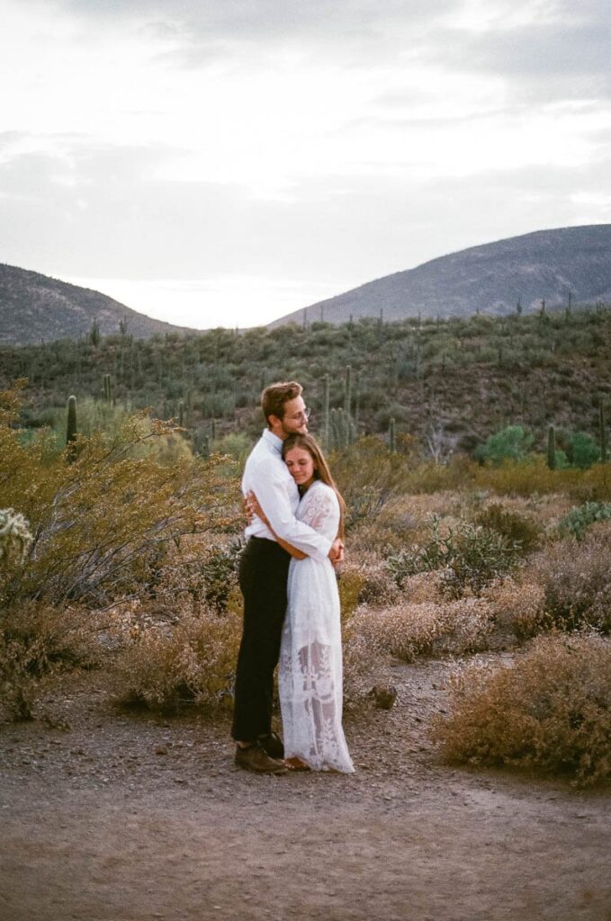 Couple hugs one another in the desert after eloping in Arizona.
