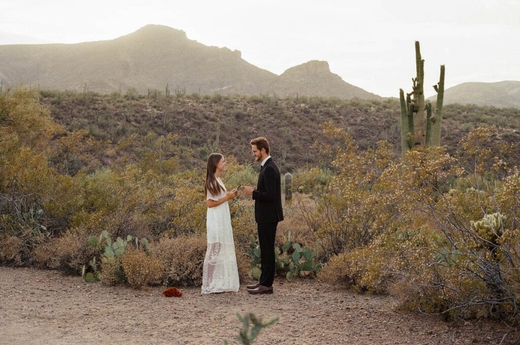 Couple says vows to one another in the desert while eloping in Arizona.