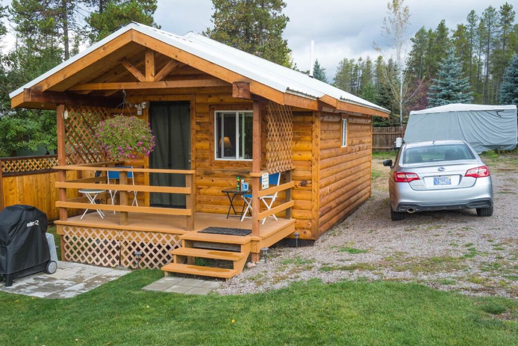 Tiny cabin Airbnb in Montana with parked car next to it.