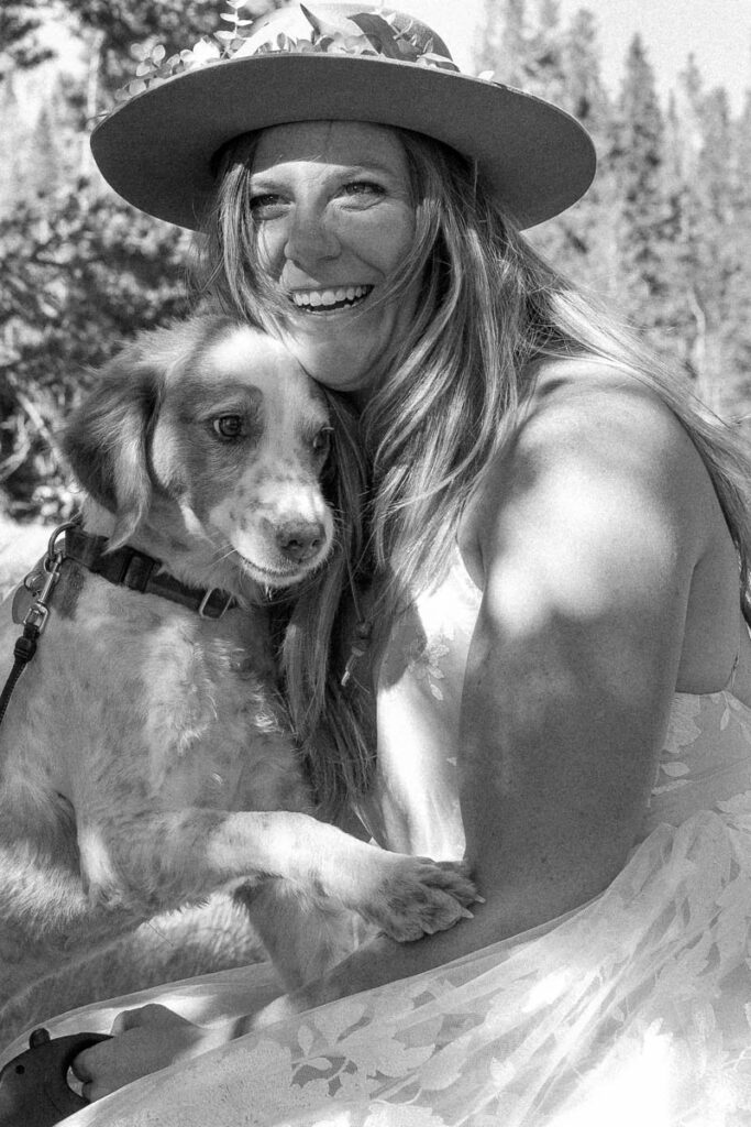 Black and white image of bride hugging her dog.