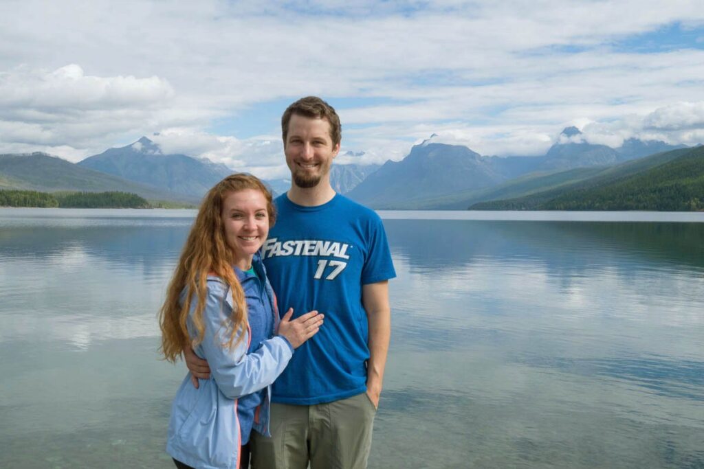 Couple standing in front of Lake MacDonald in Glacier National Park.