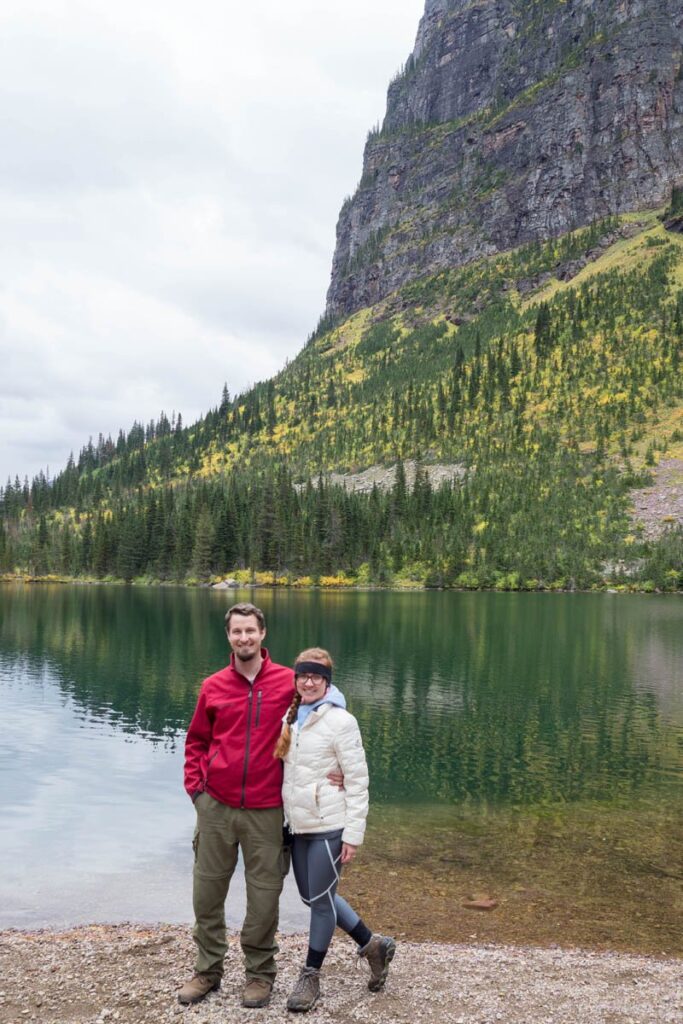 Couple bundled up in warm clothes standing in front of No Name Lake at Glacier National Park.