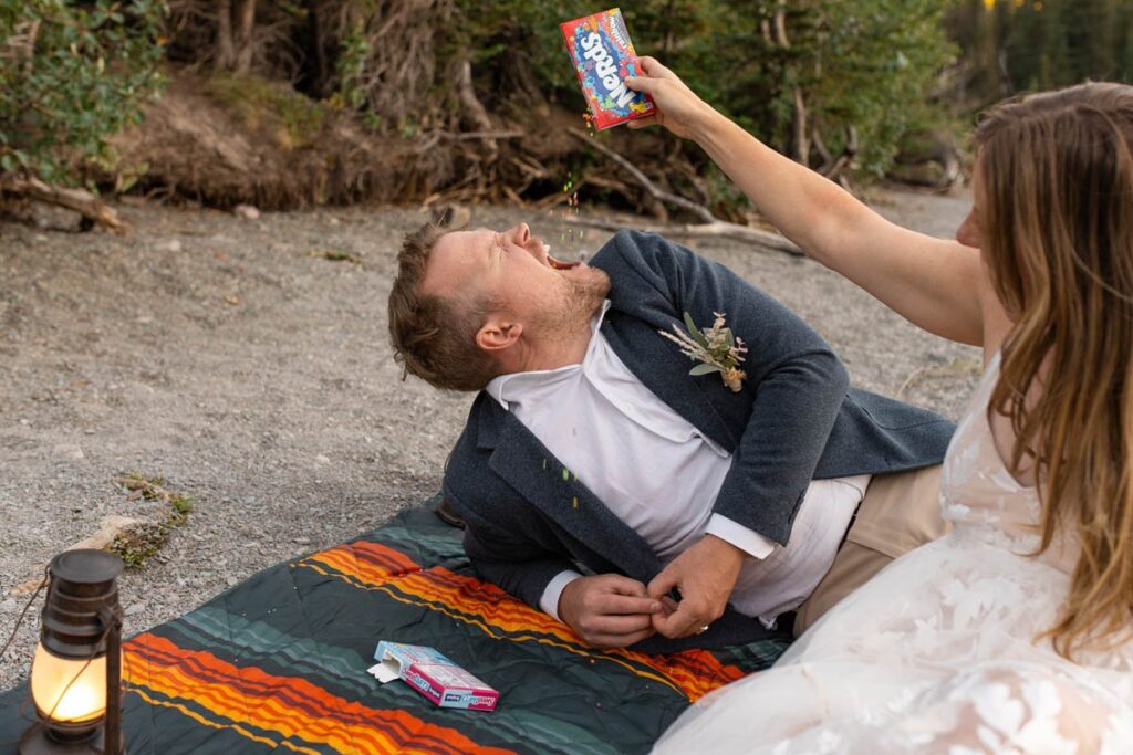Bride pours candy, Nerds, into groom's mouth.