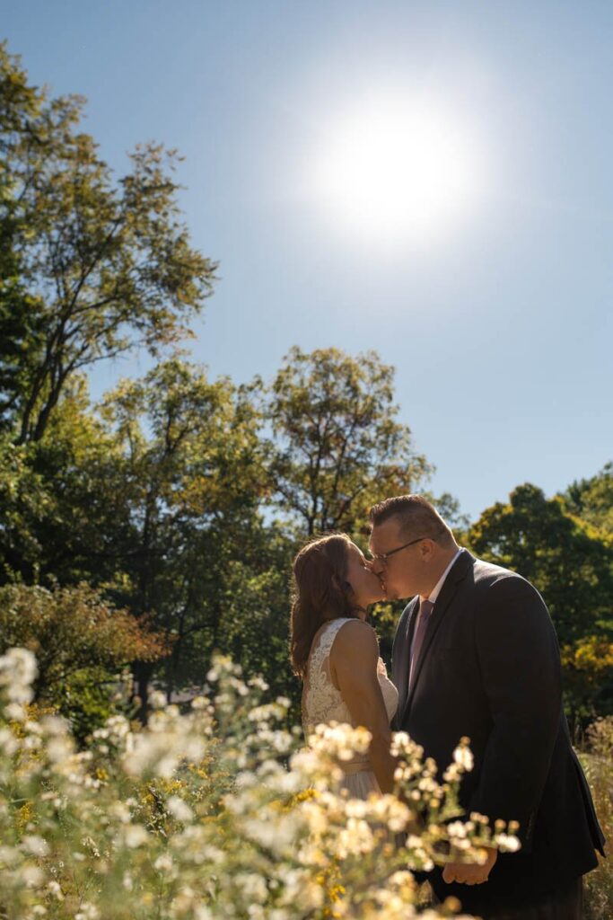 Bride and groom kiss among the wildflowers at Indiana elopement.
