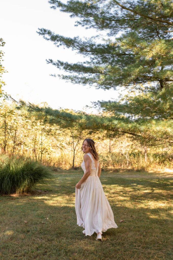 Bride frolics and runs in the grass in her wedding dress.
