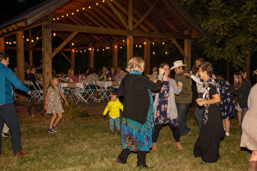 Wedding guests dance at outdoor reception.