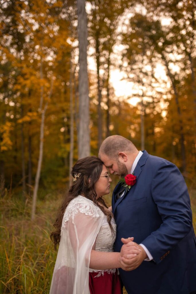 Bride and groom dance together outside during beautiful fall sunset.