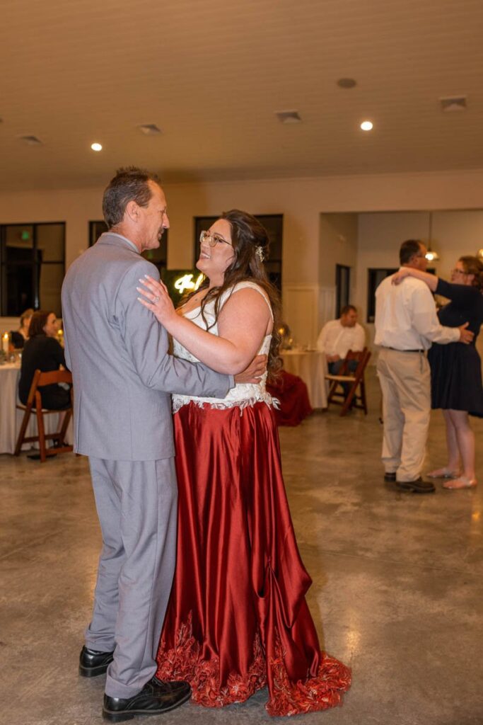 Father dances with the bride during wedding reception.