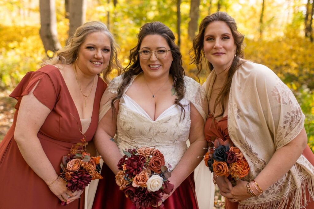 Bride smiling surrounded by her bridesmaids for fall wedding.