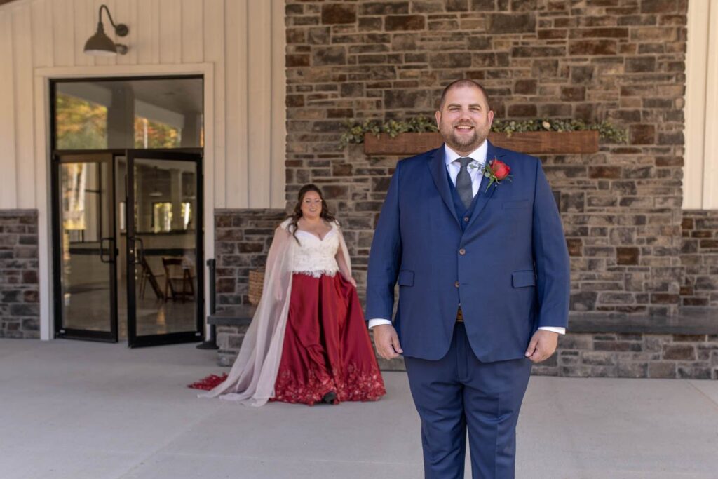 Bride walks up to groom during their first look at their Owl Ridge wedding,