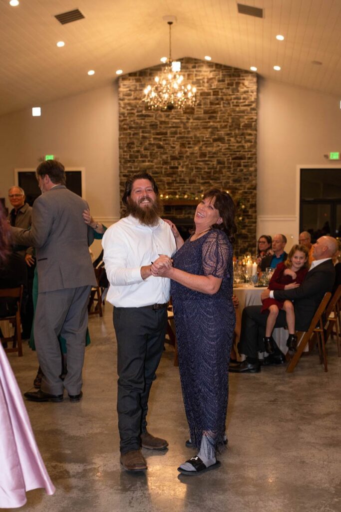 Mother dances with her son during a wedding reception.