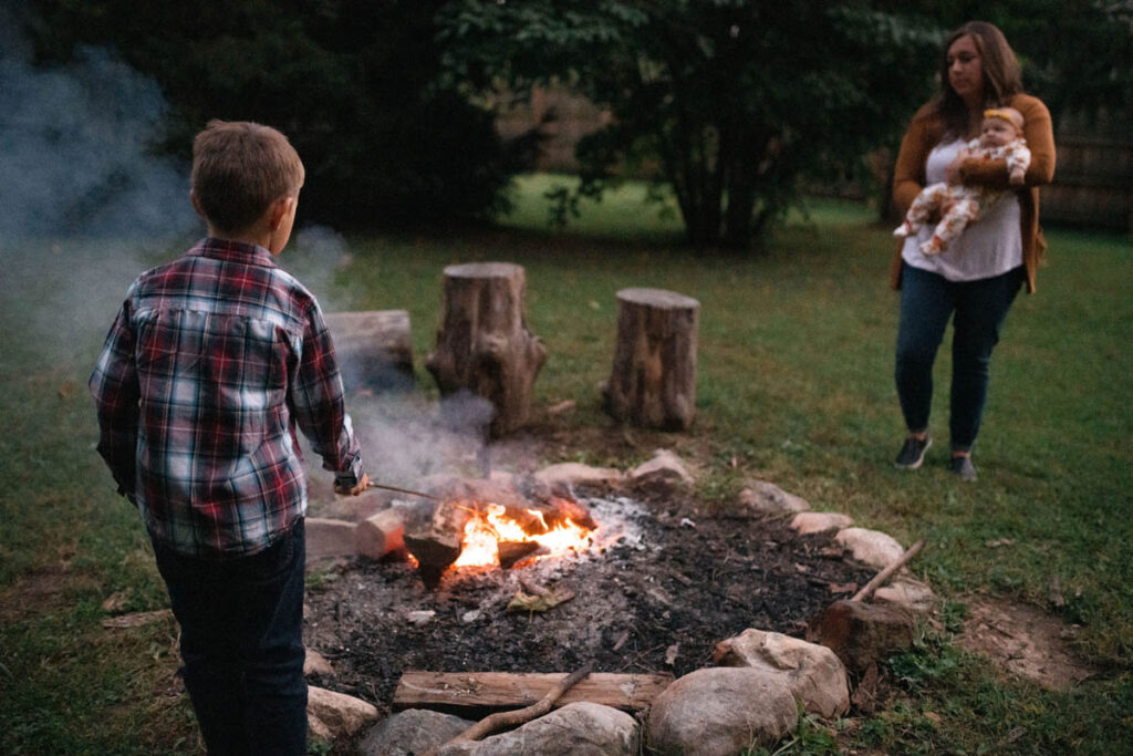 Boy roasting marshmallows over campfire.