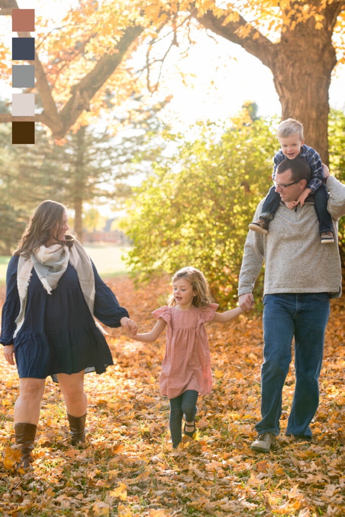 Family walks together through leaves for their fall photo session.