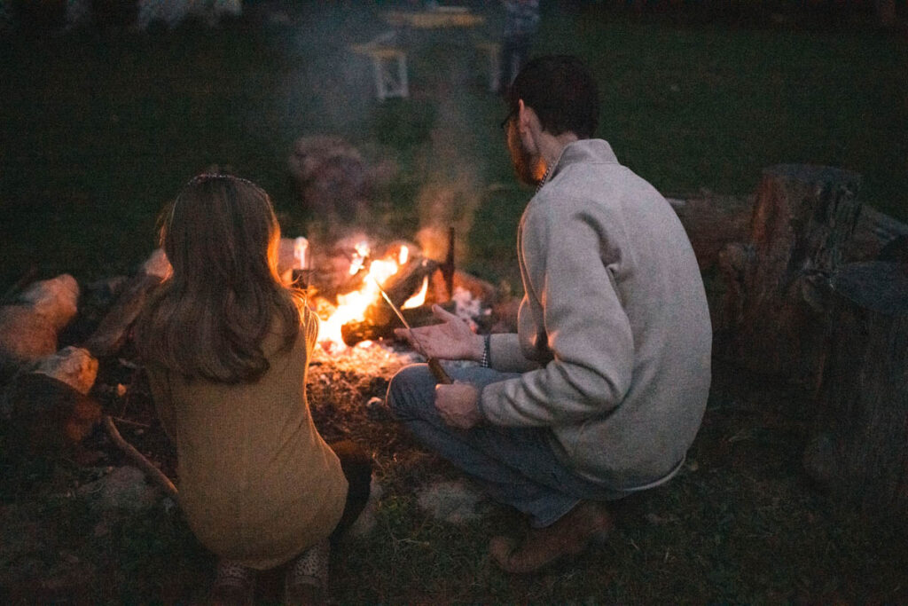 Father and daughter roasting marshmallows together.