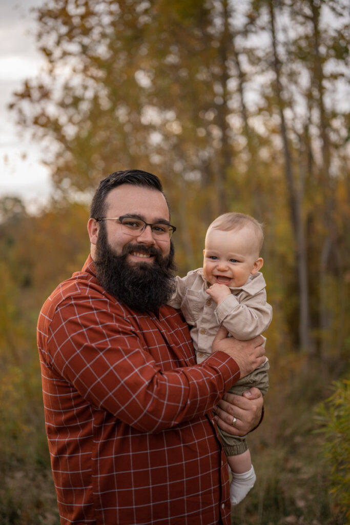 Father holds laughing son.