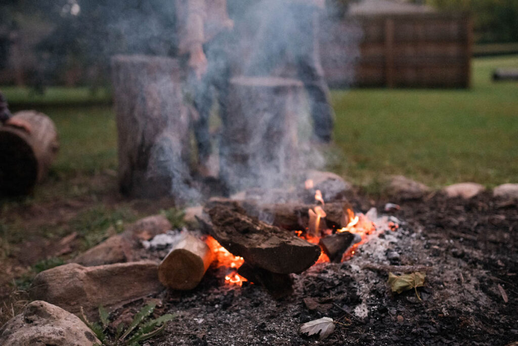 Campfire burning in backyard at night.
