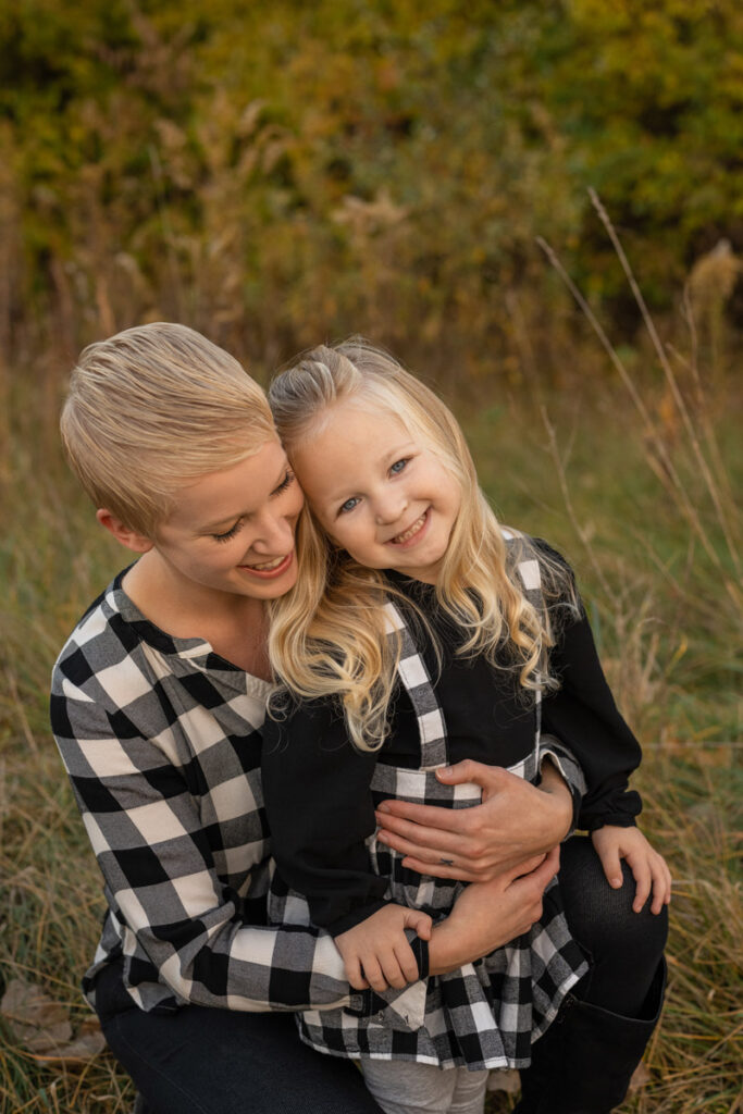 Mother and daughter smiling and wearing buffalo plaid.