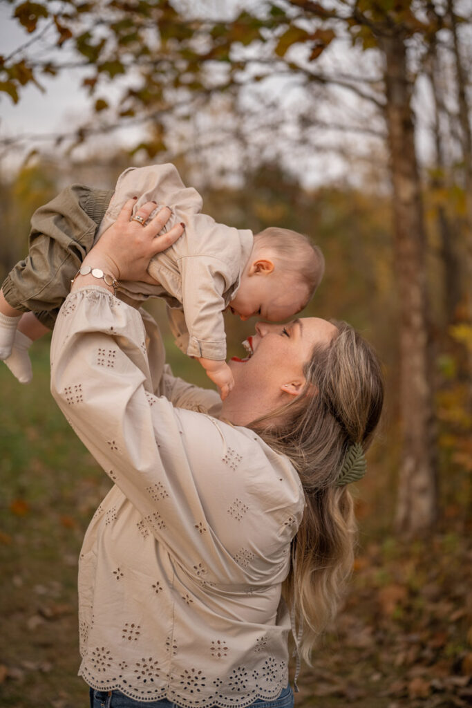 Mother holds up smiling son.