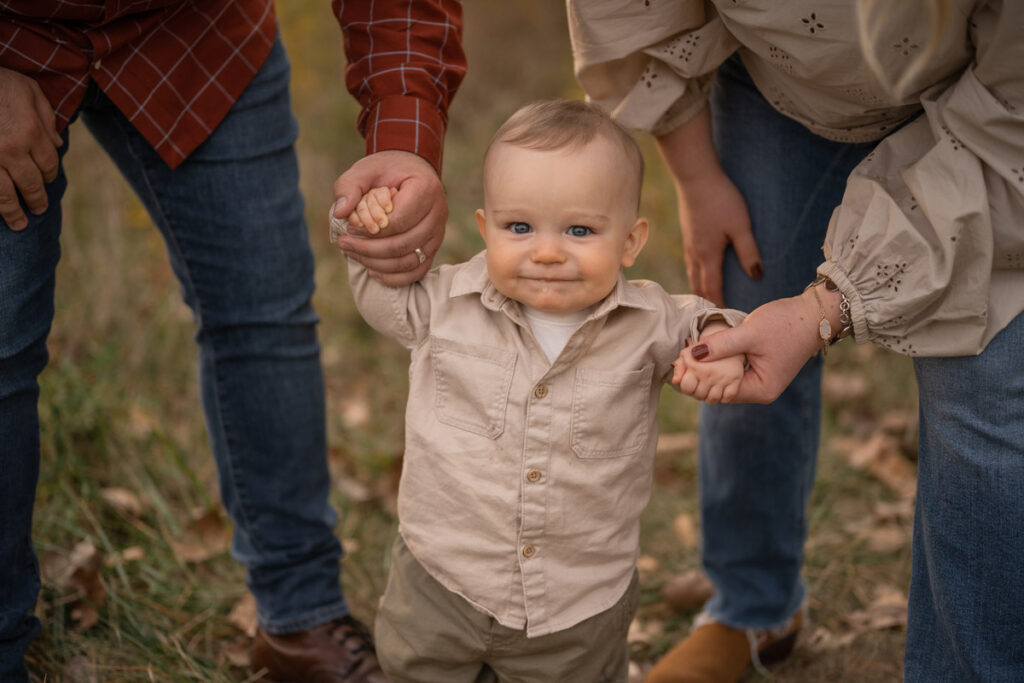 Parents walk with smiling son.