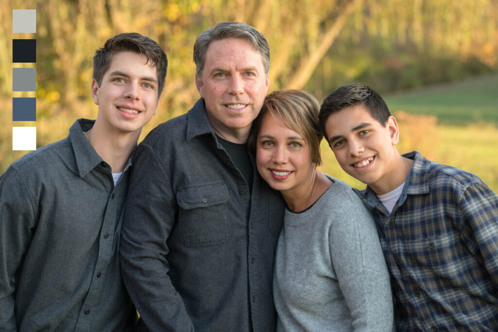 Family of four wears different grey tones at sunset for fall photo session.