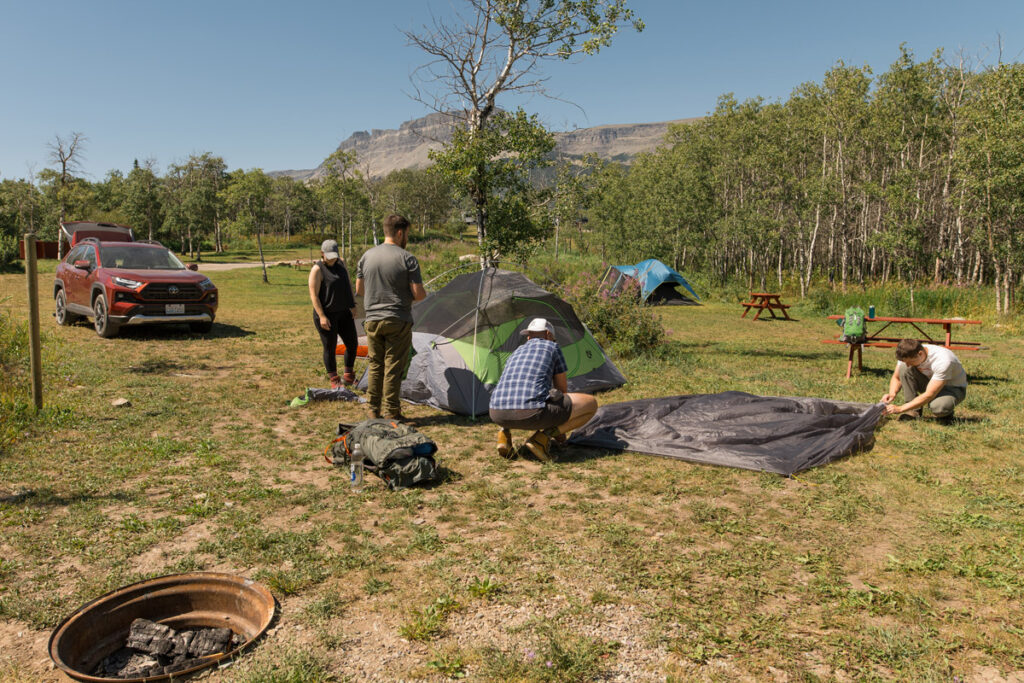 Group of hikers make camp at a campsite.