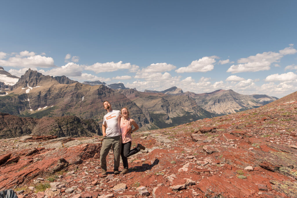 Hikers posing silly on trop of red rock mountain range.