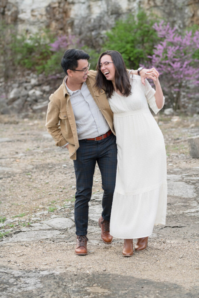 Couple laughs while stumbling and walking together.