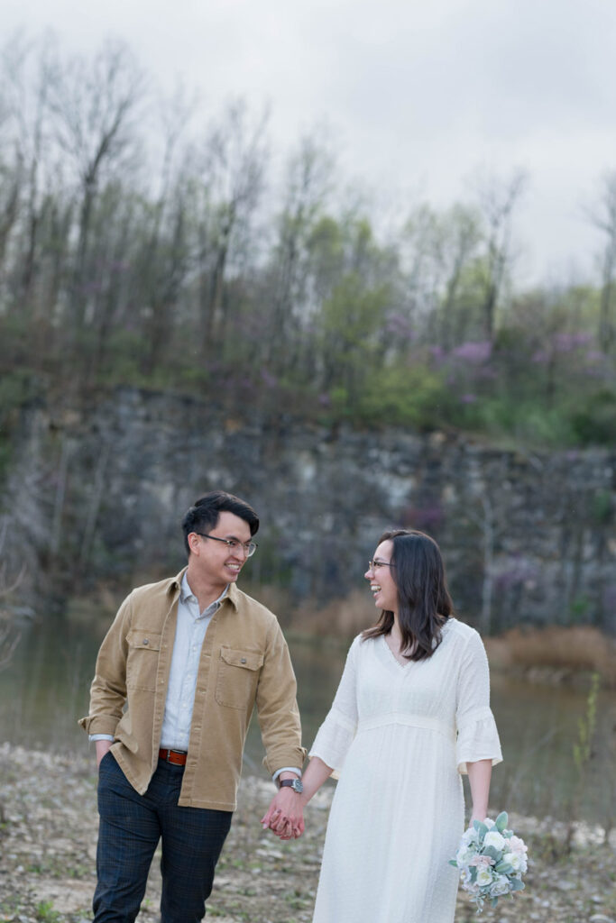 Couple walks while holding hands and looking at each other.