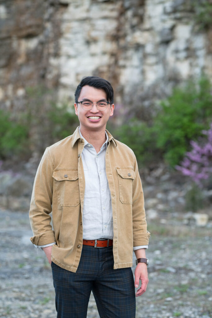 Man smiling with his hand in his pocket.