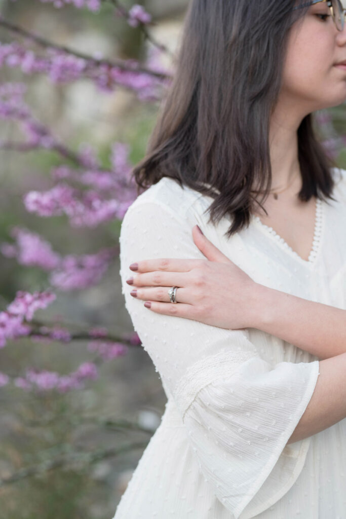 Woman holds her arm showing her wedding rings.