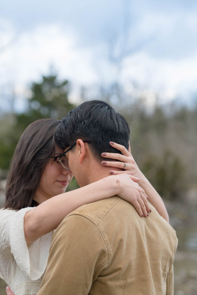 Woman holds man's face close to hers.