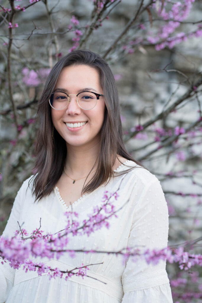 Woman smiling white standing among purple flowers.