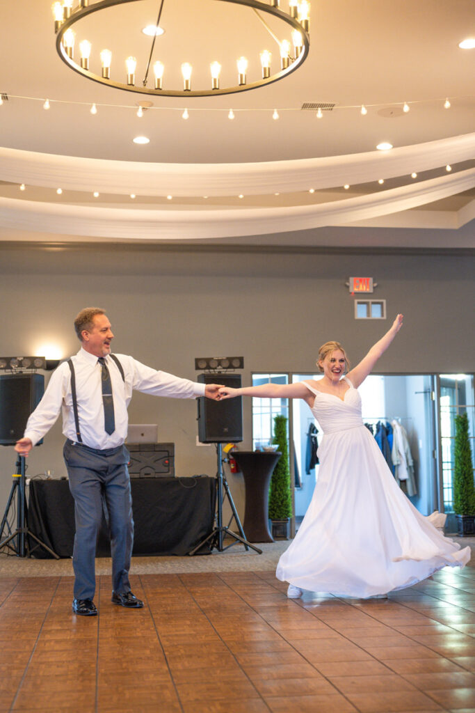 Father of bride dances happily with his daughter.