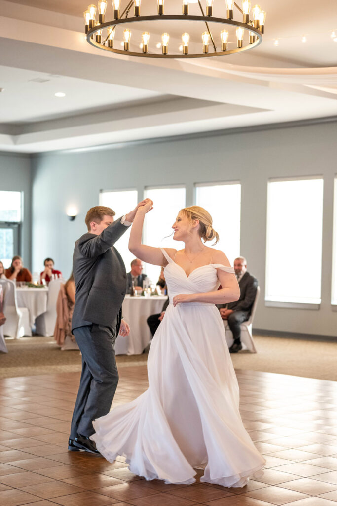 Groom spins bride during their first dance at their wedding reception at The Cardinal Room.
