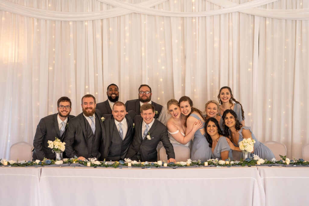 Couple during photo dash with their wedding party at the head table.