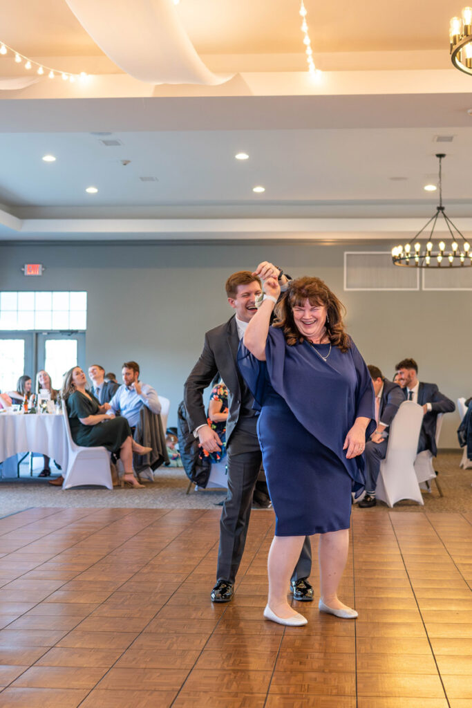 Groom twirls mother during the mother and son dance.