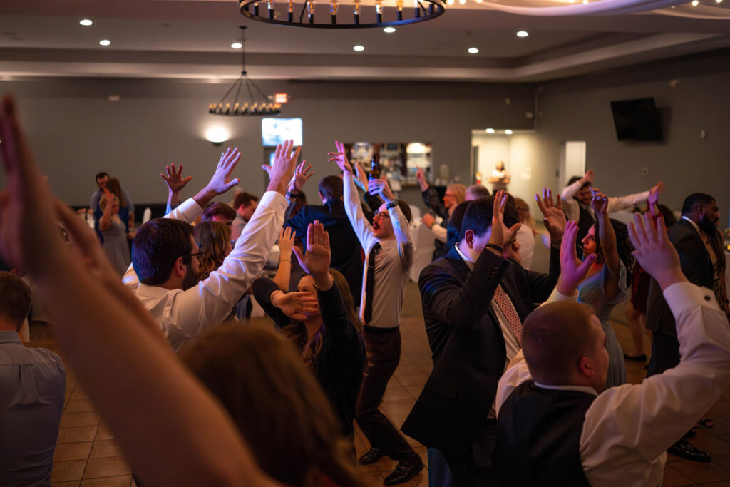 Guests have their hands in the air dancing at a wedding reception at The Cardinal Room in Lebanon, Indiana.