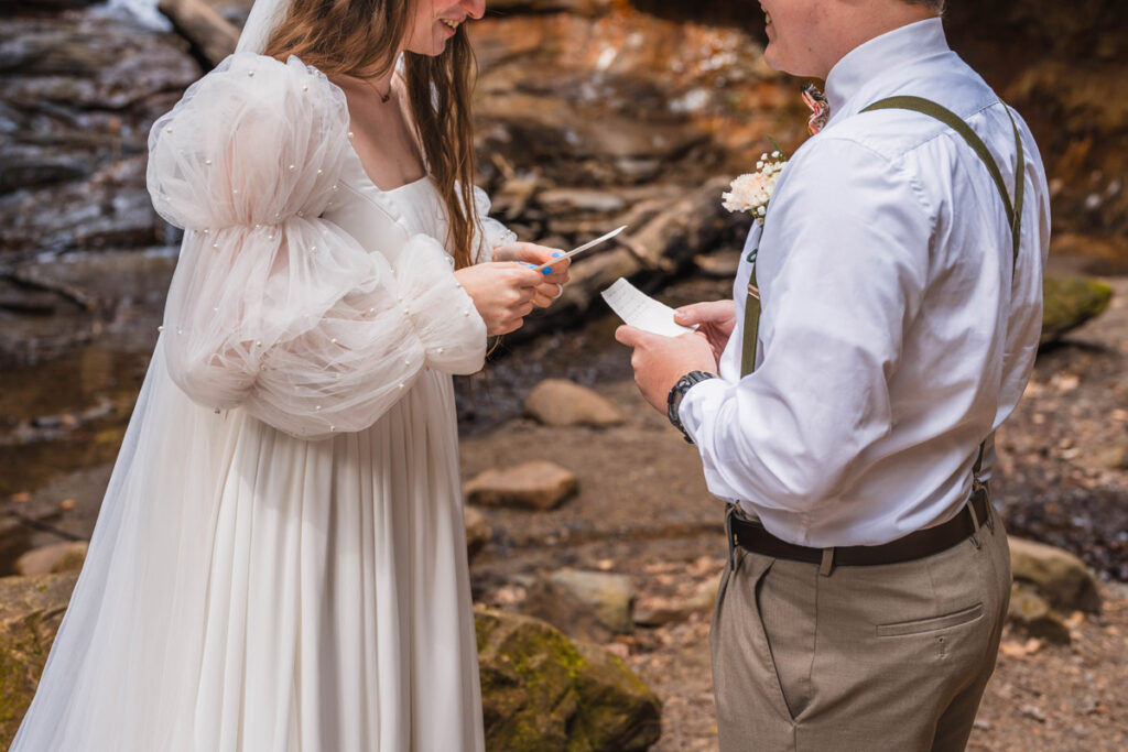 Couple looks at their hand-written vows as they share them.