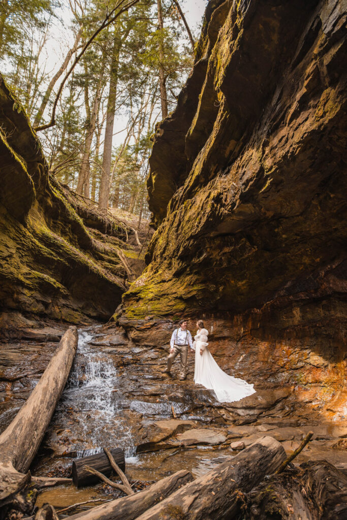 Couple chooses to elope in Indiana at Turkey Run State Park standing next to a waterfall.