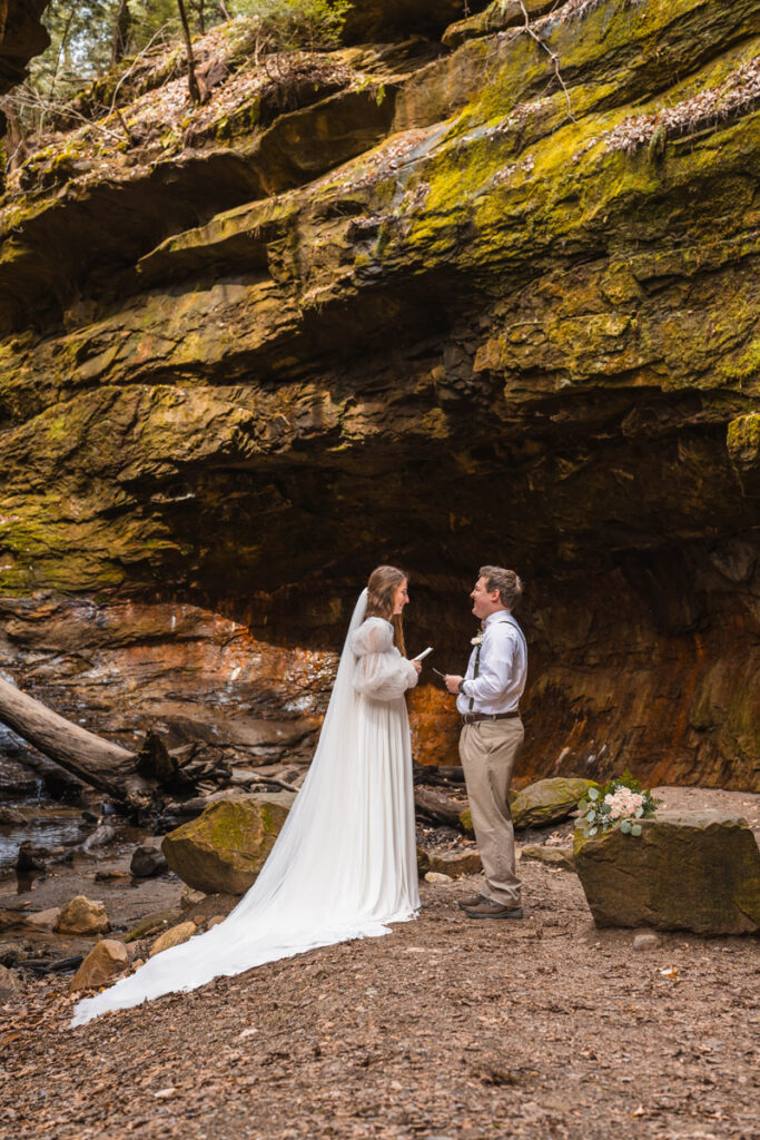 Bride and groom laugh while sharing their vows during their elopement at Turkey Run State Park.