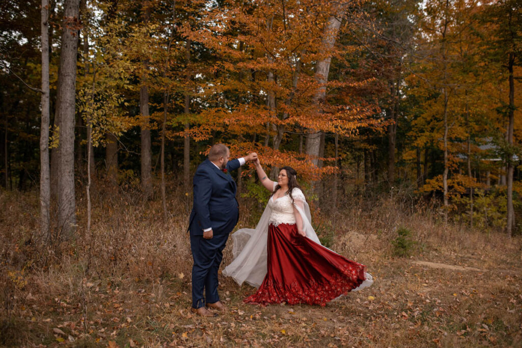 Groom twirls bride in her custom made red gown.