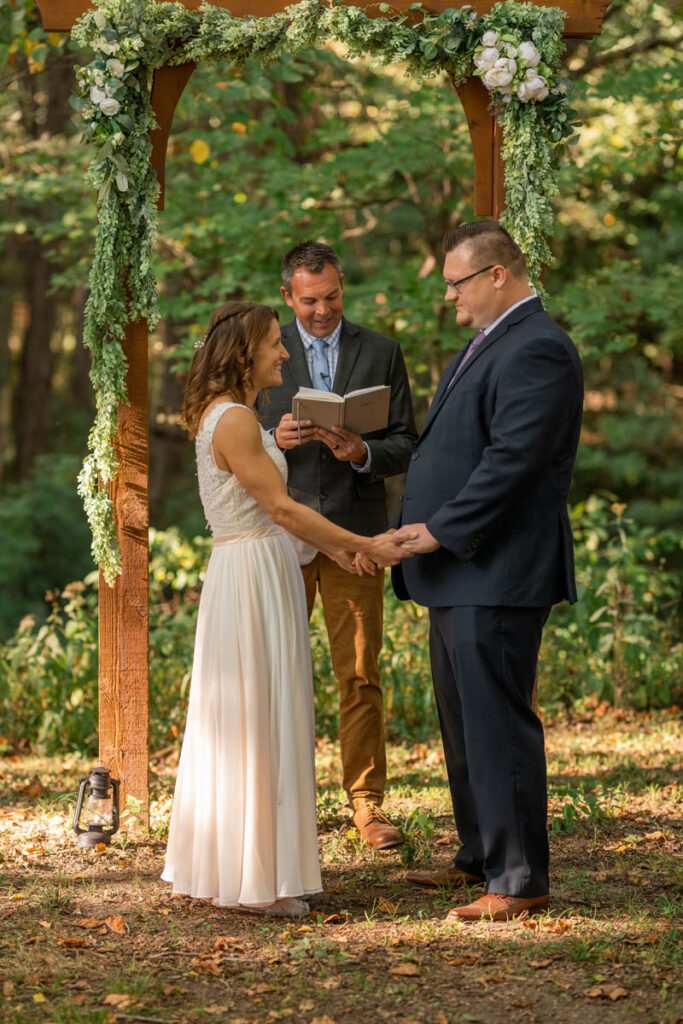 Bride and groom exchange vows during a forest wedding.