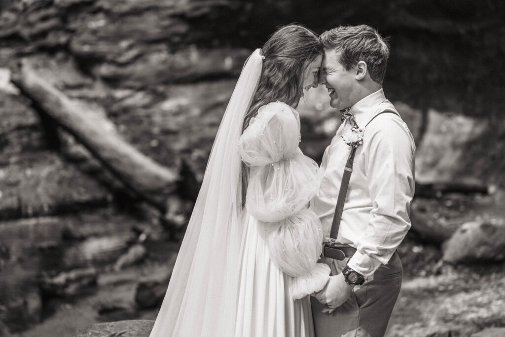 Husband and wife elope in Turkey Run State Park laughing while holding hands.