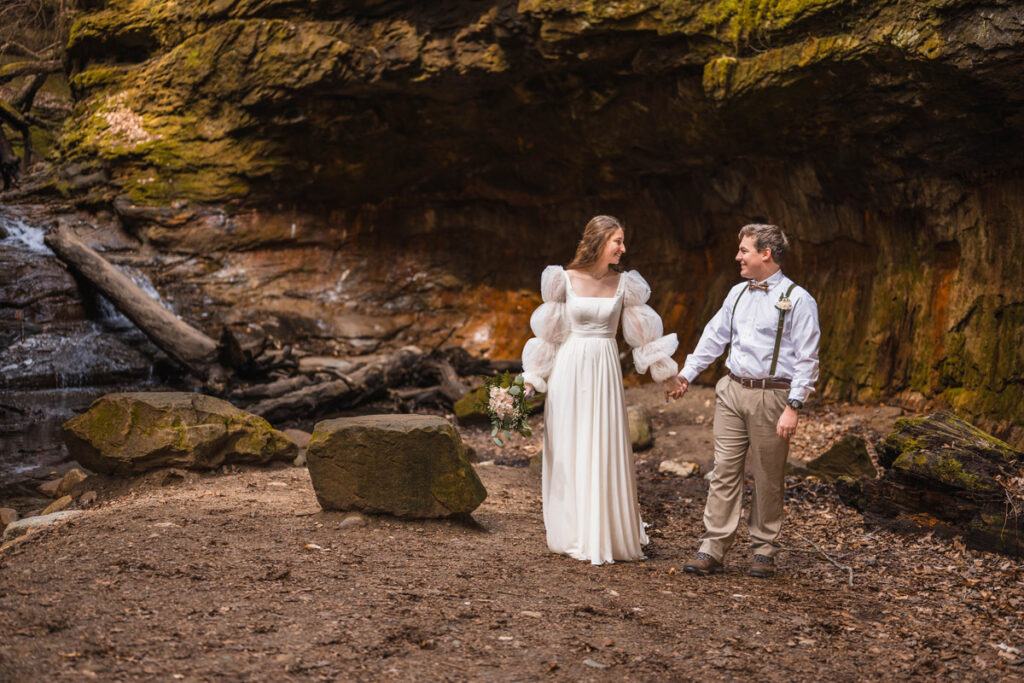 Bride and groom holding hands while they elope in Turkey Run State Park in Indiana.