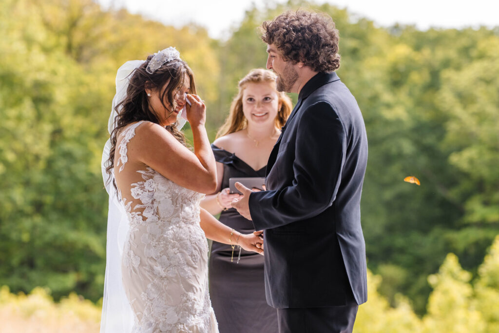 Bride and groom share an emotional moment during their outdoor wedding ceremony at The Wilds.
