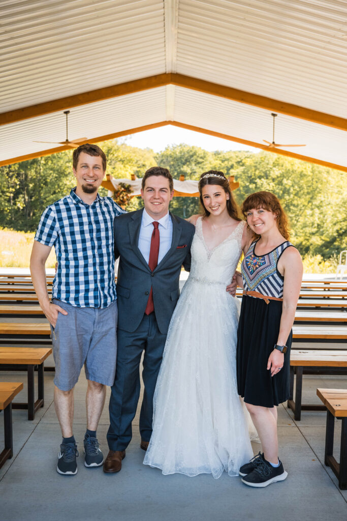 Bride and groom smile with another couple after their outdoor wedding ceremony at The Wilds.
