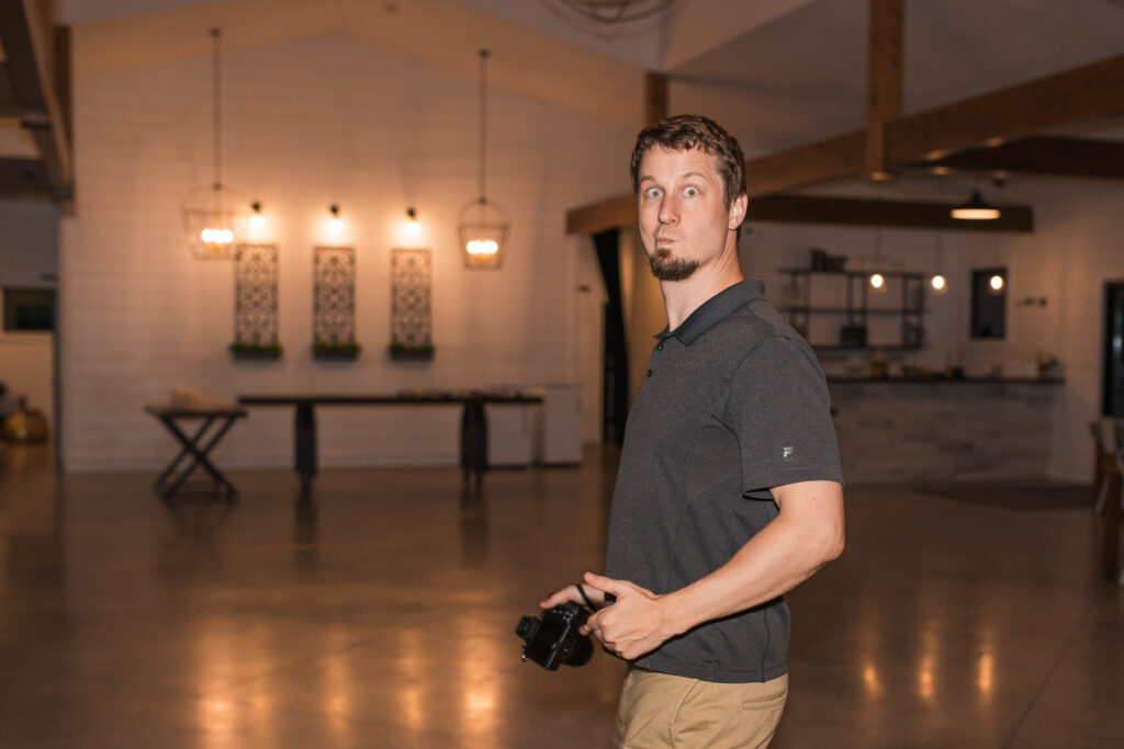 Male photographer makes a silly face at wedding reception.