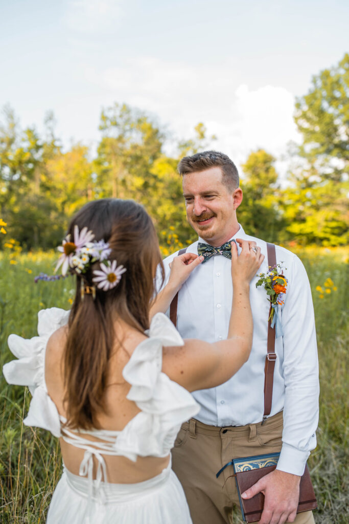 Bride straightens groom's bowtie before their elopement.