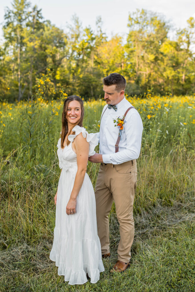 Groom ties bride's dress as they get ready for their elopement.