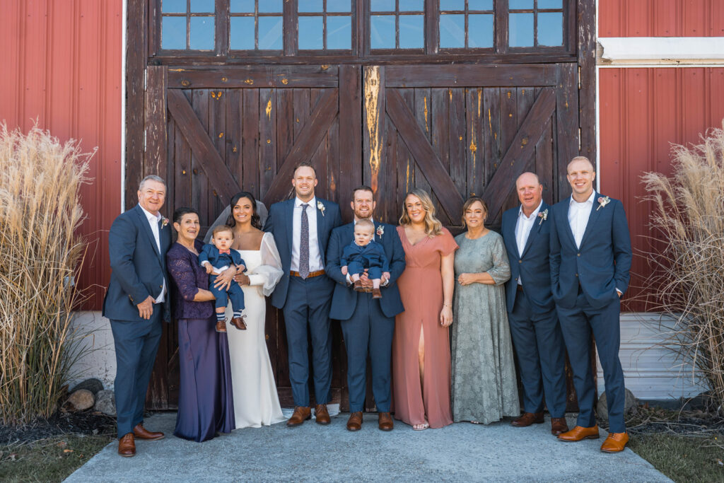 Bride and groom smiling with their families.